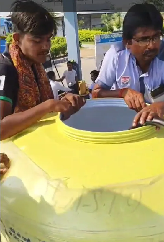 पानी की टंकी में डीजल पेट्रोल भरते हुए पेट्रोल टंकी का कर्मचारी